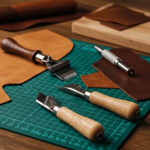 Beginner leatherworking tools and materials arranged on a cutting mat